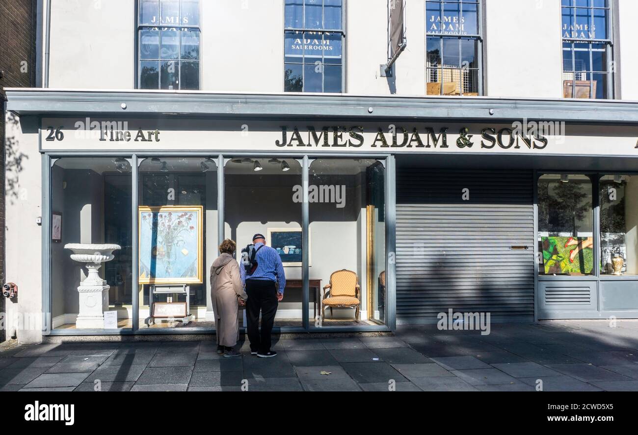 Gente viendo la ventana de James Adams & Sons, Subastas de Bellas Artes en St Stephens Green, Dublín, Irlanda. Foto de stock