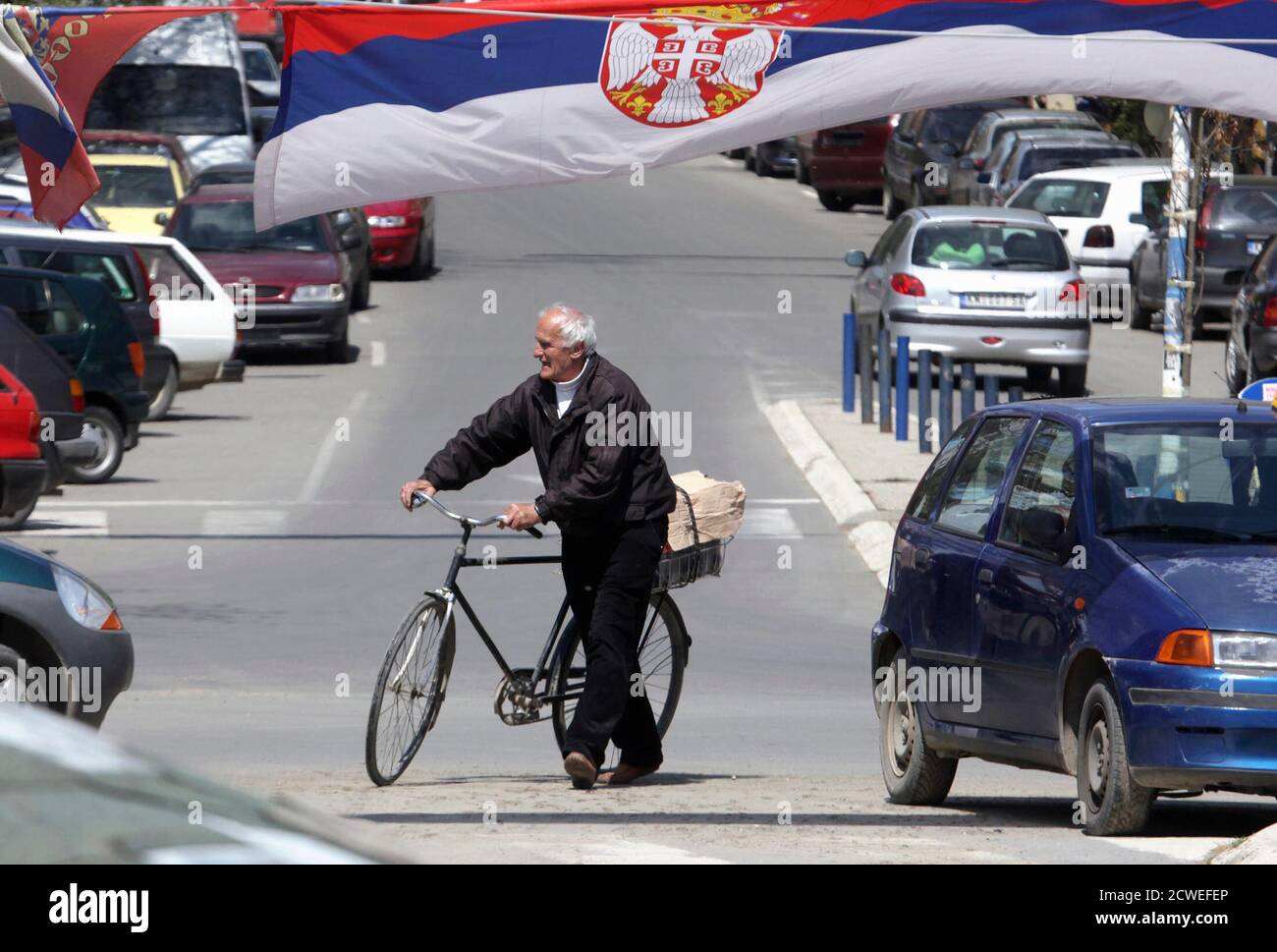 A man passes near Serbian flags in northern part of the ethnically divided  town of Mitrovica April 17, 2013. The European Union gave Serbia a last  chance to clinch membership talks with