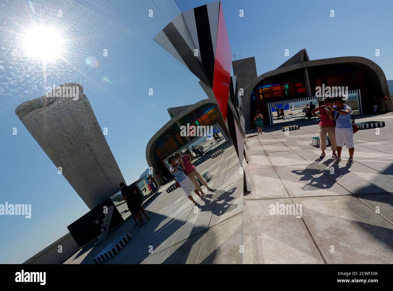 Visitors walk past a creation as part of the exhibition "Defini Fini Infini, Travaux in situ" by French artist Daniel Buren at the MaMo art center in Marseille September 12, 2014. The MaMo contemporary art center is installed on the restored rooftop terrace of Le Corbusier's 1947 Cite Radieuse (Radiant City) and created by French designer Ora-Ito. The exhibition will run until September 30, 2014. REUTERS/Jean-Paul Pelissier (FRANCE - Tags: ENTERTAINMENT SOCIETY) Foto de stock