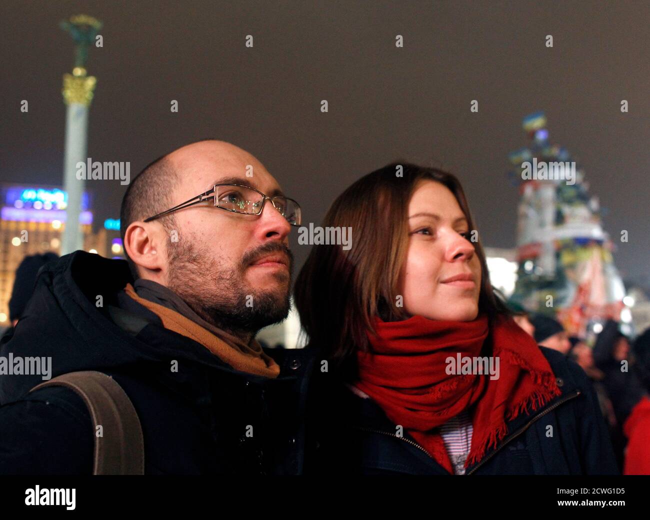 Igor Skliarevsky y su esposa Elena asisten a una reunión pro-europea en la Plaza de la Independencia en Kiev, el 16 de diciembre de 2013. De día, Igor Skliarevsky trabaja como diseñador gráfico. Por la noche, es un manifestante anti-gubernamental, a veces manejando las barricadas en la capital nevada de Ucrania. El joven de 36 años entrega mapas para los compañeros manifestantes, dirigiéndolos a puestos médicos o cocinas. También creó un sitio web que coordinaba alimentos, ropa de abrigo y otros suministros para los acampados en la Plaza de la Independencia de Kiev. Foto tomada el 16 de diciembre de 2013. REUTERS/Vasily Fedosenko (UCRANIA - Tags: POLÍTICA CIVIL UNRE Foto de stock