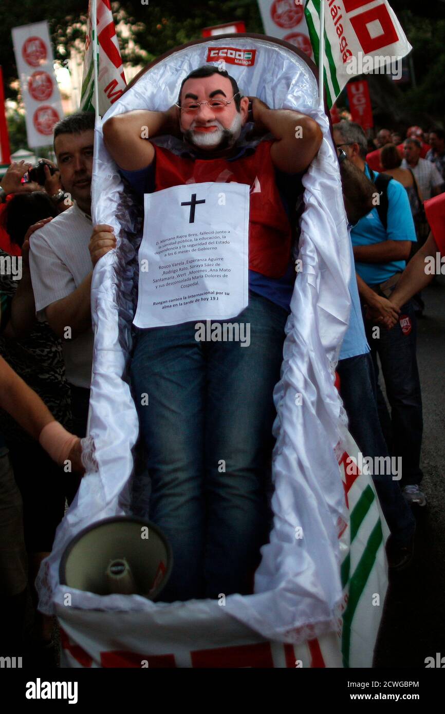 Juan Antonio Torres, de 42 años, trabajador social y miembro de las  Comisiones Obreras (CCOO), se encuentra en un ataúd mientras lleva una  máscara del primer ministro español Mariano Rajoy durante una