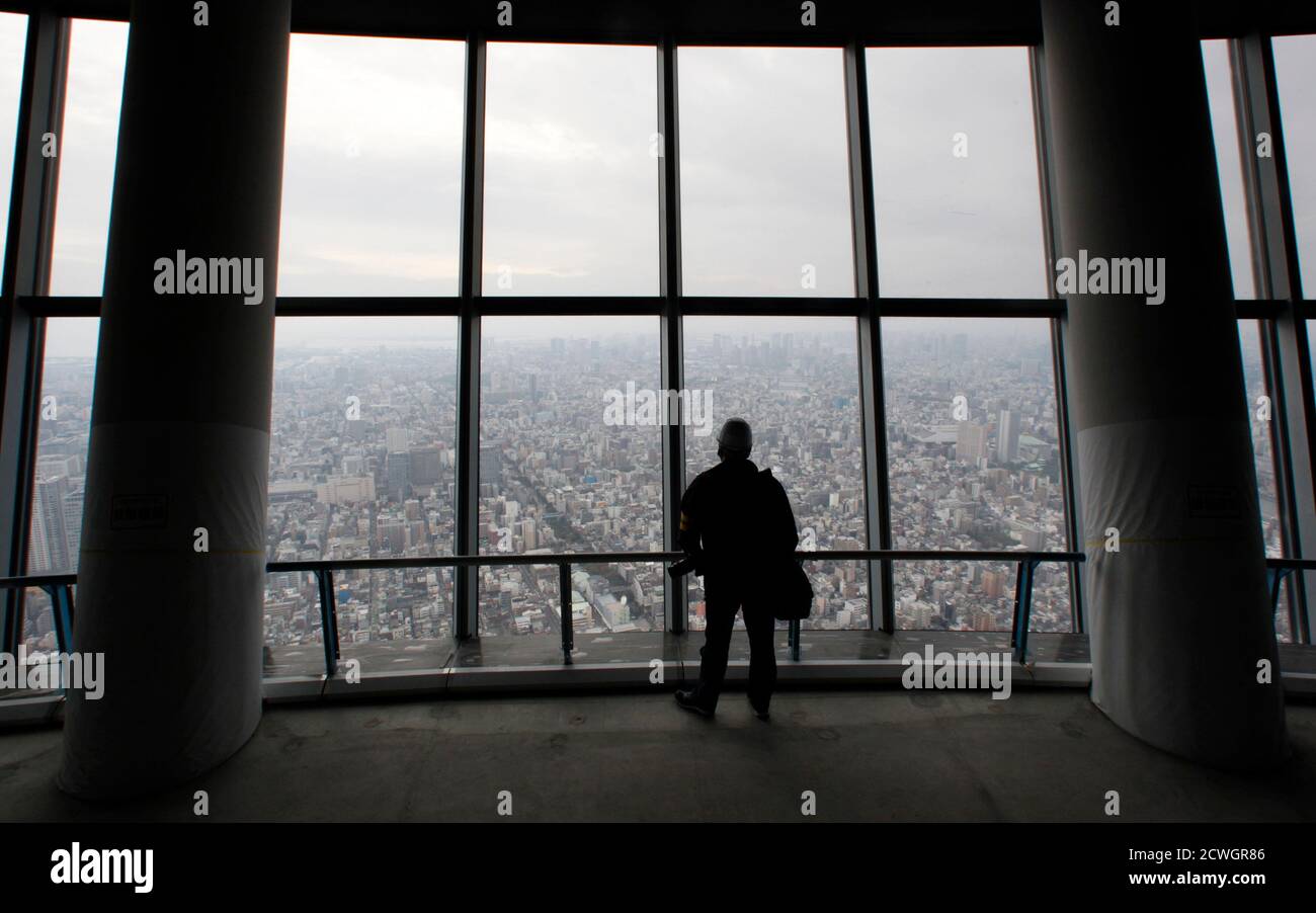 Un fotógrafo observa una vista panorámica de la ciudad de Tokio desde la primera plataforma del observatorio durante una vista previa de los medios en Tokyo Sky Tree en Tokio el 30 de octubre de 2011. El Tokyo Sky Tree, que está en construcción, estará a 634 metros (2,080 pies) de altura una vez terminado, y será la torre de comunicaciones independiente más alta del mundo. La gran inauguración del Tokyo Sky Tree es el 22 de mayo de 2012. REUTERS/Issei Kato (JAPÓN - Tags: CIENCIA TECNOLOGÍA CITYSPACE) Foto de stock
