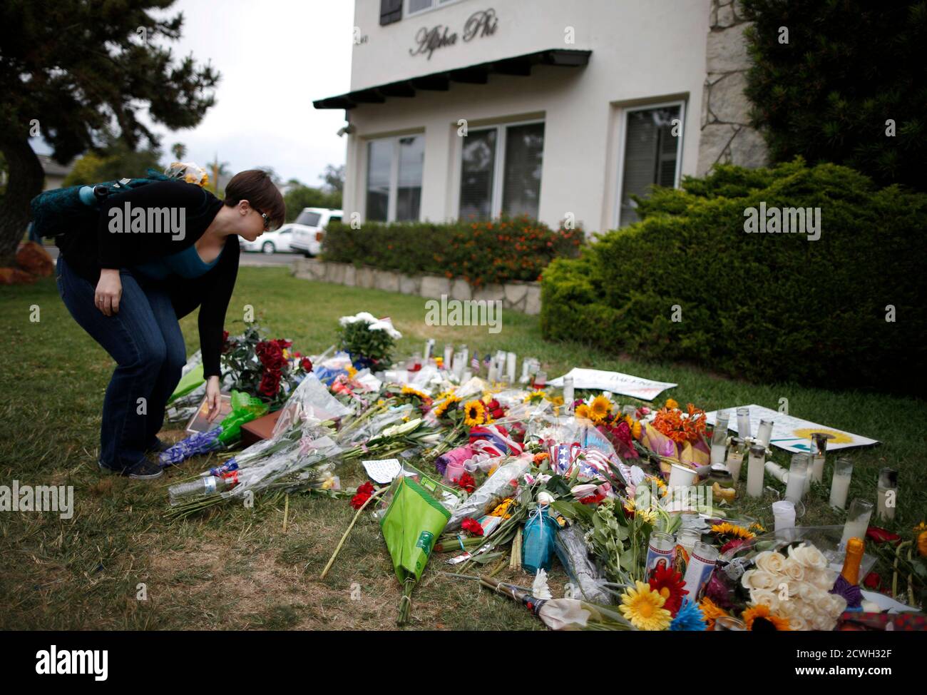 University of California, Santa Barbara (UCSB) graduate student Lauren Koch, 25, lays flowers at a makeshift memorial in front of the Alpha Phi sorority house where two women were killed in the Isla Vista neighborhood of Santa Barbara, California May 26, 2014. Twenty-two year old Elliot Rodger killed six people before taking his own life in a rampage through a California college town shortly after he posted a threatening video railing against women, police said on Saturday. REUTERS/Lucy Nicholson (UNITED STATES - Tags: CRIME LAW) Foto de stock
