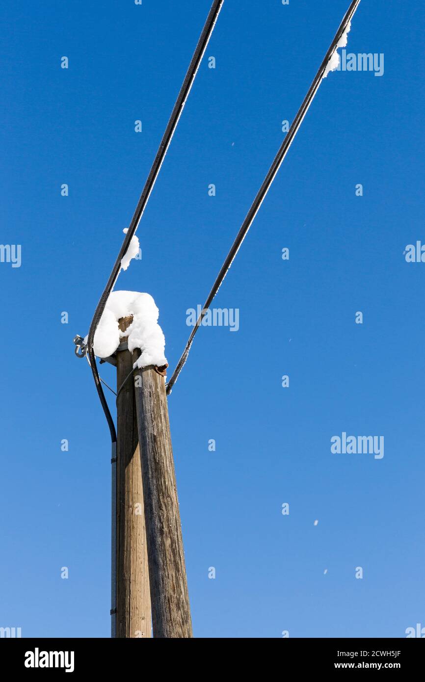 Telegrapenmast, verschneit, blauer Himmel Foto de stock