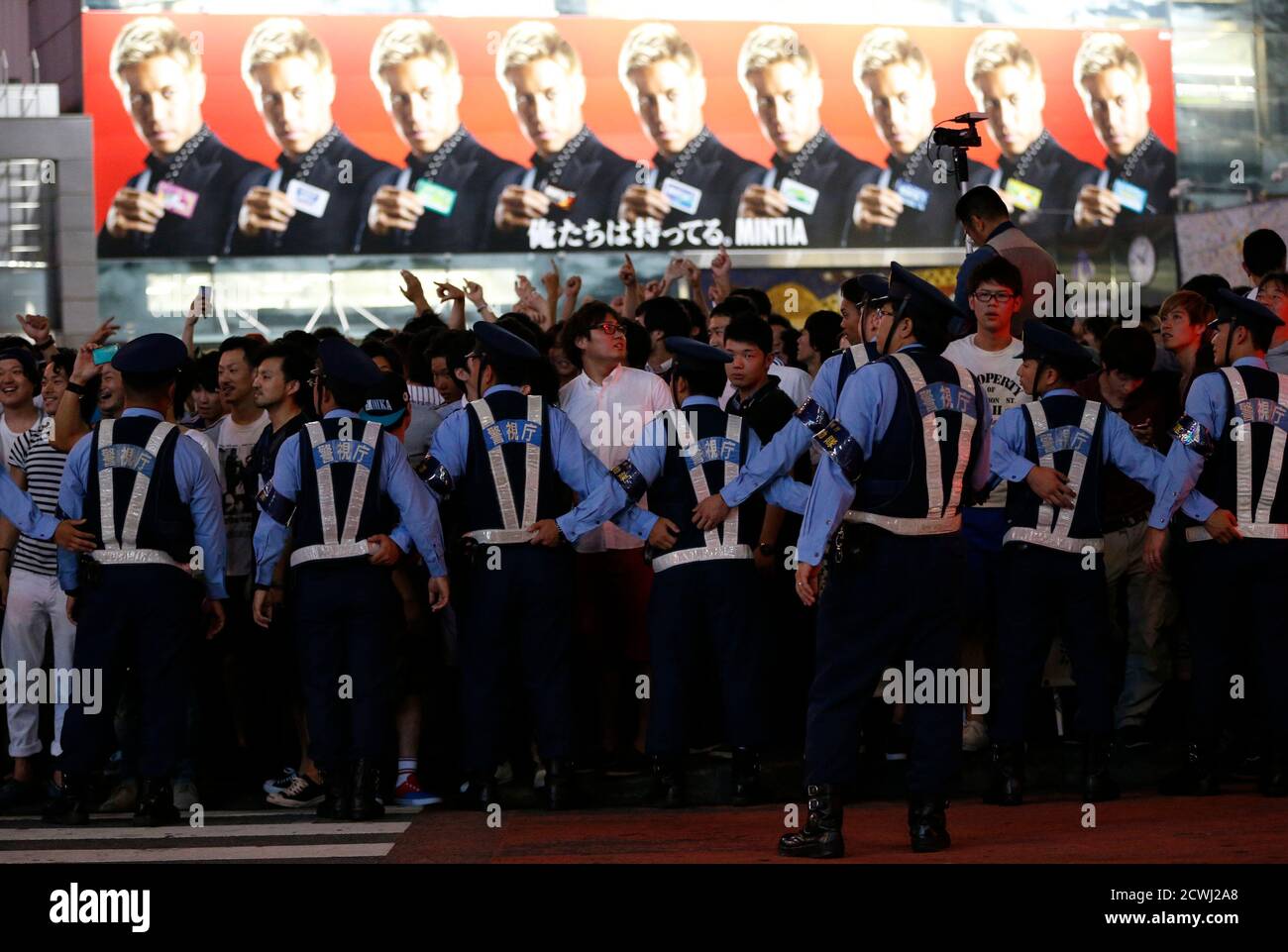 Police Officers Try To Control Japanese Soccer Fans And Pedestrians As They Celebrate Japan S Qualification For The World Cup Finals In Brazil As An Advertisement Of Japan Team S Keisuke Honda Is Seen Police Officers Try To Control Japanese Soccer Fans And Pedestrians As They Celebrate Japan S Qualification For The World Cup Finals In Brazil As An Advertisement Of Japan Team S Keisuke Honda Is Seen