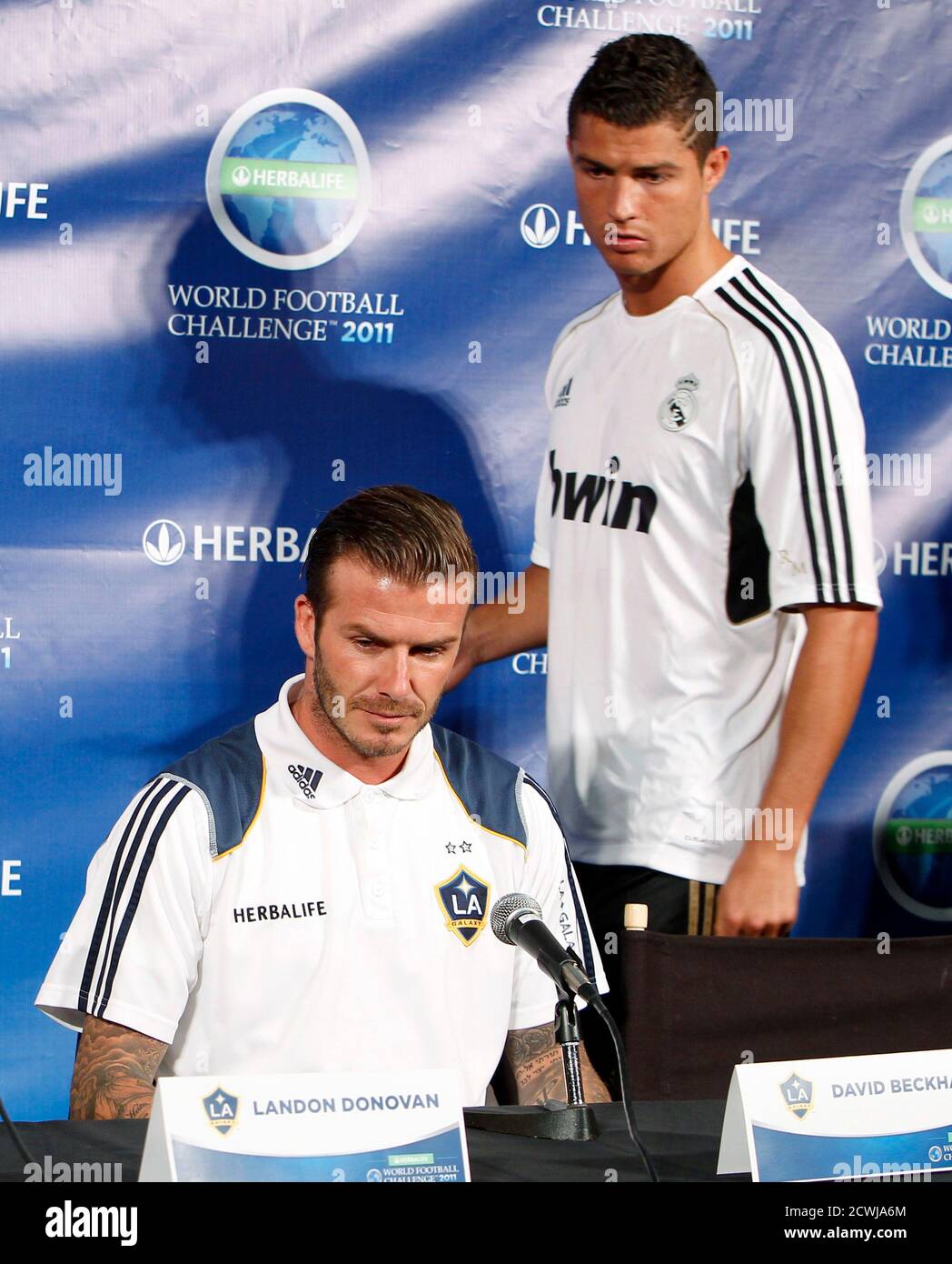 LA Galaxy's David Beckham (L) sits down as Real Madrid's Cristiano Ronaldo  looks for his seat at a news conference to announce the Herbalife World  Football Challenge 2011 soccer tournament in Los