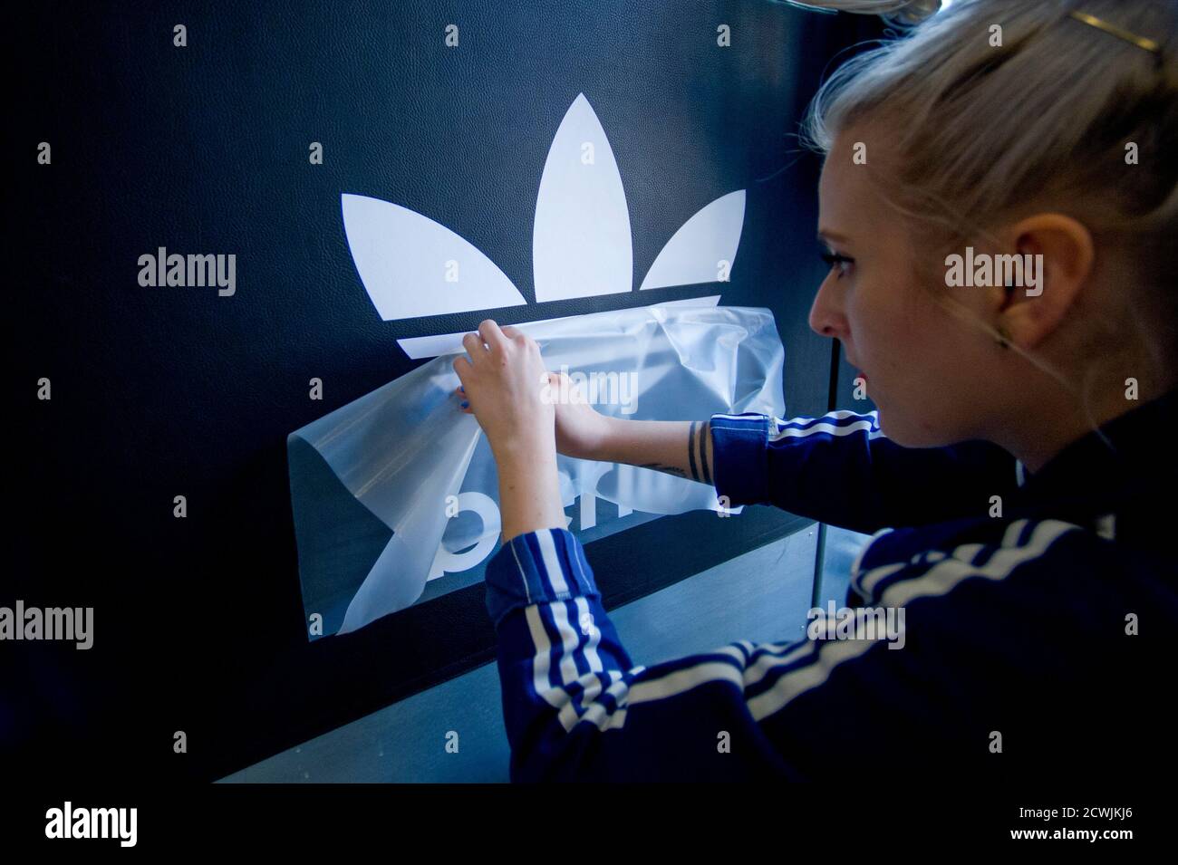 Un trabajador prepara un logo para la apertura de la nueva tienda de originales Adidas en Berlín el 27 de marzo de 2014. ha un nuevo modelo de para