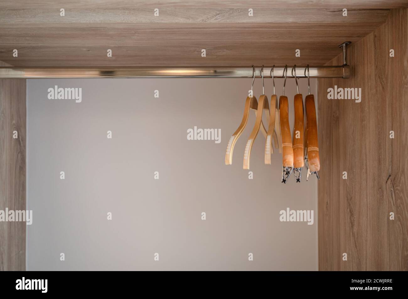 Dos perchas blancas están en ganchos cerca de la pared de madera en blanco,  foto de fondo vertical Fotografía de stock - Alamy