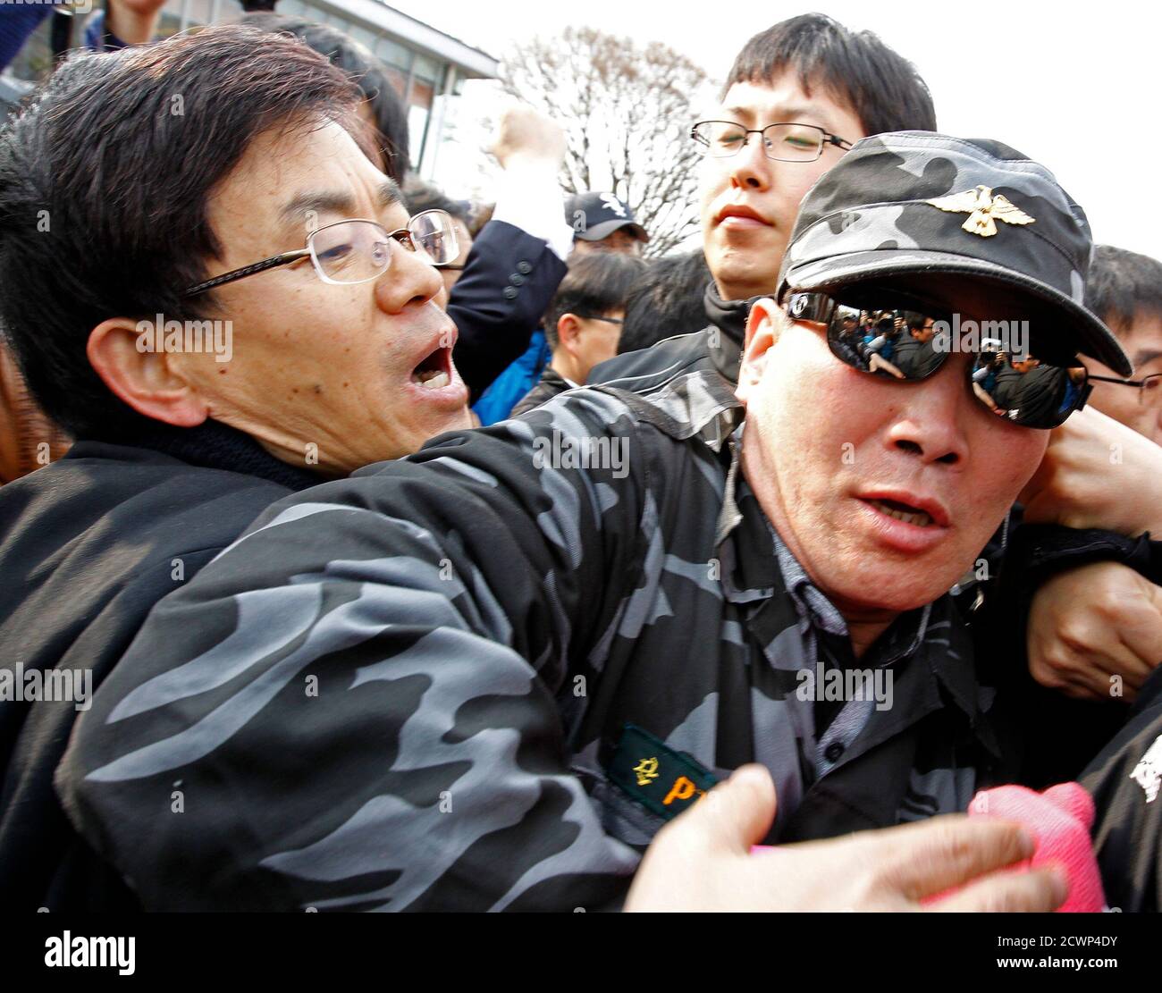 Un activista contra la guerra (L) lucha con un desertor norcoreano que era un ex soldado en el Ejército Popular de Corea del Norte mientras trata de impedir el evento de panfleto anti-Kim Jong-il del desertor en el pabellón de Imjingak, cerca de la zona desmilitarizada que separa las dos Coreas en Pajulu, a unos 55 km (34 millas) norte de Seúl, 29 de abril de 2011. Los ex desertores norcoreanos y activistas de derechos humanos lanzaron el viernes unos 200,000 folletos anti-Pyongyang, DVD anti-Corea del Norte, radios y 1,000 billetes de un dólar. El líder norcoreano Kim Jong-il está dispuesto a mantener conversaciones directas con Corea del Sur, pero con la isola Foto de stock
