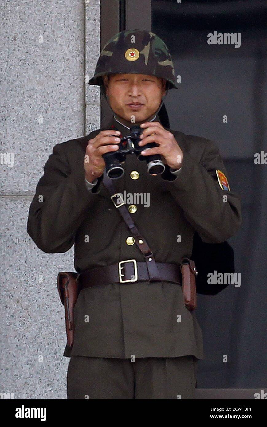 A North Korean Soldier Looks South As He Holds A Pair Of Binoculars On The North Side Of The Truce Village Of Panmunjom In The Demilitarized Zone Separating The Two Koreas In A North Korean Soldier Looks South As He Holds A Pair Of Binoculars On The North Side Of The Truce Village Of Panmunjom In The Demilitarized Zone Separating The Two Koreas In