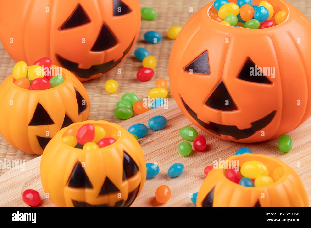 Decoraciones de Halloween usando pumkins de plástico y frijoles de gelatina en un fondo de madera Foto de stock