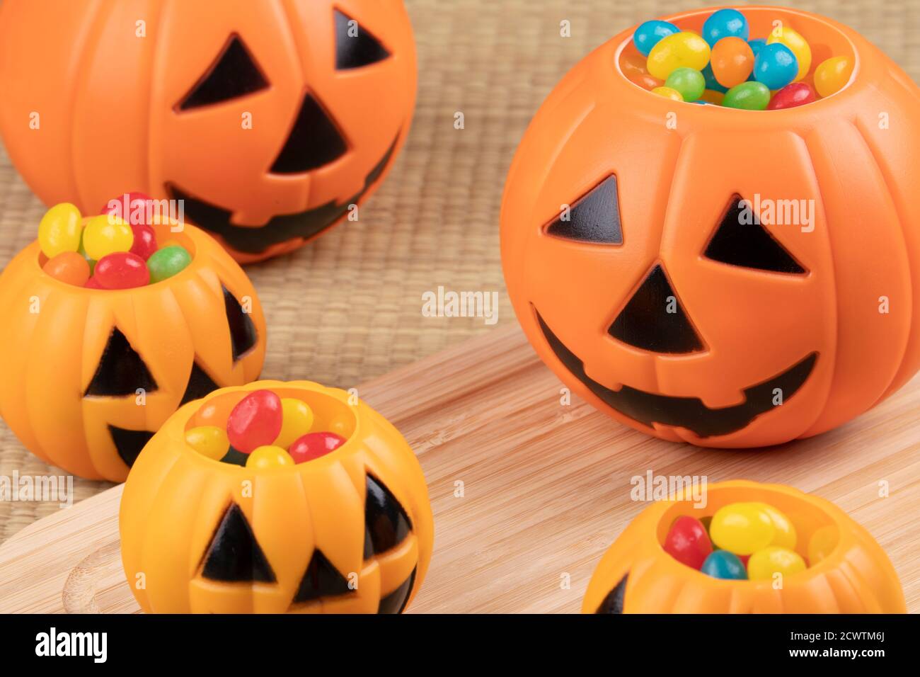 Decoraciones de Halloween usando pumkins de plástico y frijoles de gelatina en un fondo de madera Foto de stock