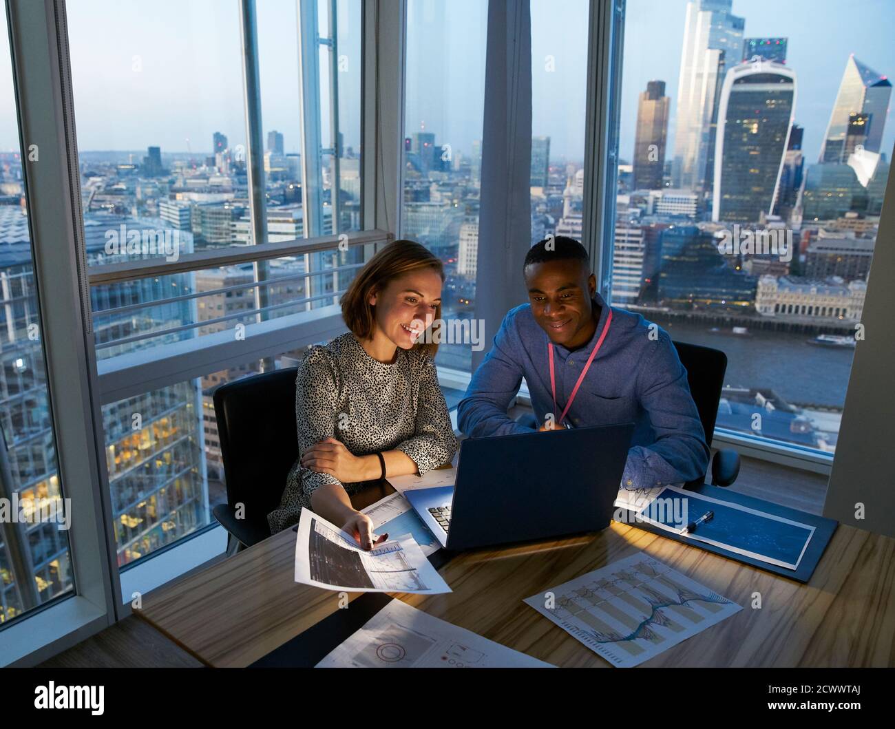 Gente de negocios que trabaja en un portátil en una oficina de gran altura, Londres, Reino Unido Foto de stock