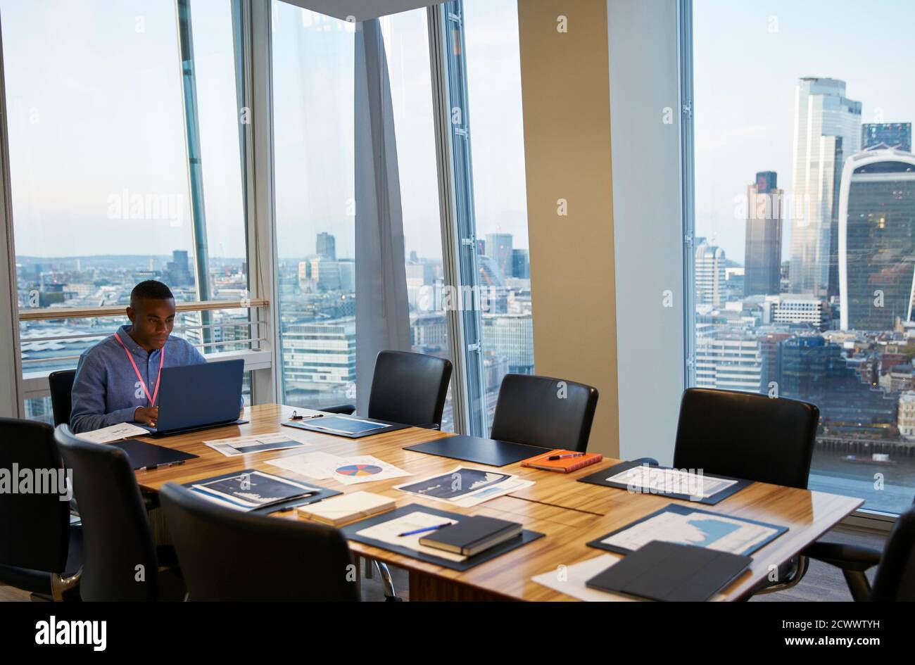 Hombre de negocios trabajando en un portátil en una sala de conferencias de gran altura, Londres, Reino Unido Foto de stock