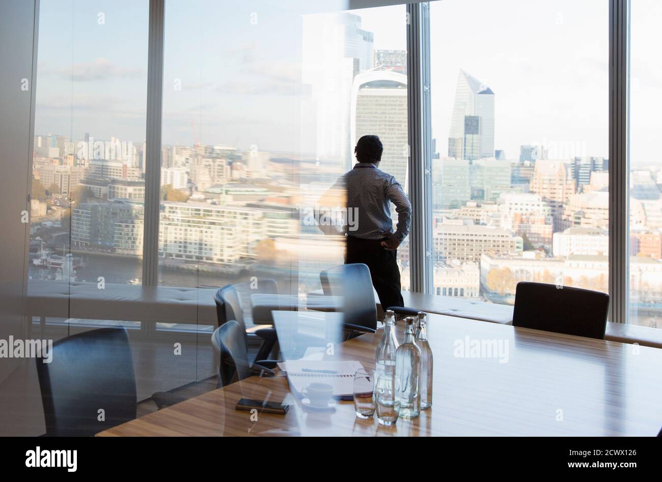Un hombre de negocios atento en una ventana de oficinas de gran altura, Londres, Reino Unido Foto de stock