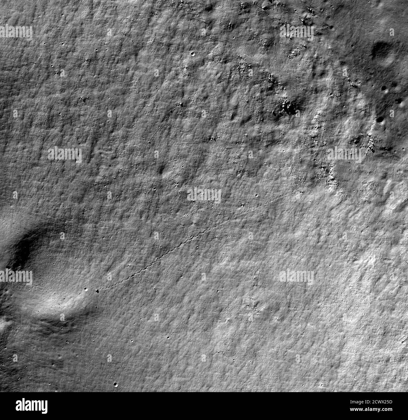 ¡casi un agujero en uno ️ en el agujero! ...bueno, casi. ⛳ hizo que esta roca en la Luna rodara solo 250 pies más, podría haber plopped cuidadosamente en un cráter. Esta imagen muestra una pequeña porción del borde del cráter Antoniadi en el lado lejano de la Luna. A veces, el material se mueve rápidamente por la pendiente en trozos discretos. Correr desde los afloramientos hasta el borde del cráter parcialmente enterrado es una pista grabada por una roca rodante más grande que un autobús. Tal vez un terremoto lo sacudió suelto. La roca rebotó y rodó hacia el cráter parcialmente enterrado, arando un camino que todavía es visible a través de la Foto de stock