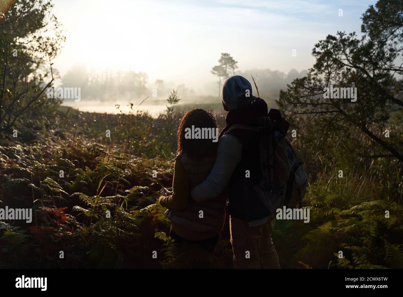 Silueta joven pareja de senderismo y disfrutar de una tranquila vista de la naturaleza Foto de stock