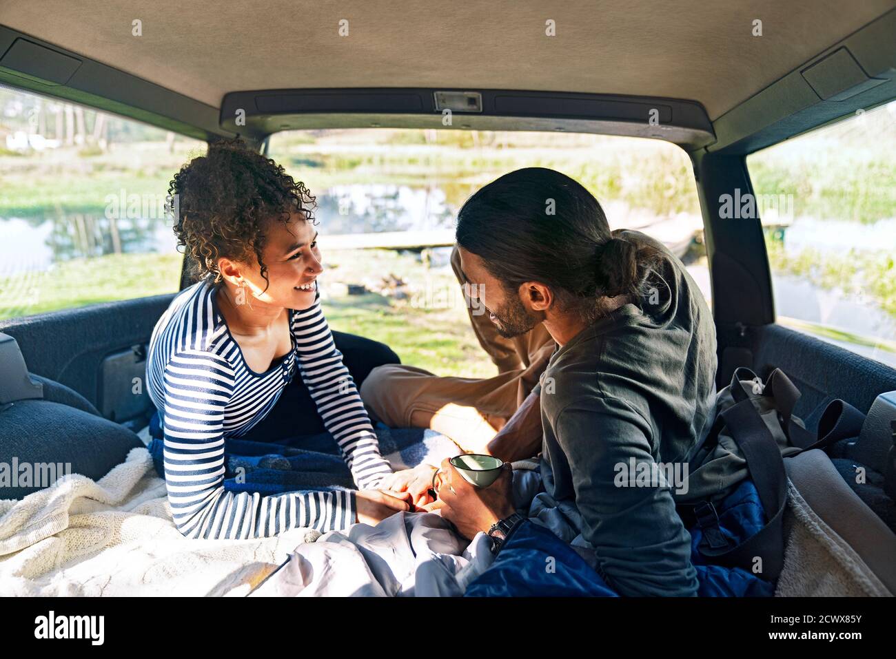 Feliz pareja joven cariñosa relajándose en la parte trasera del coche viaje por carretera Foto de stock