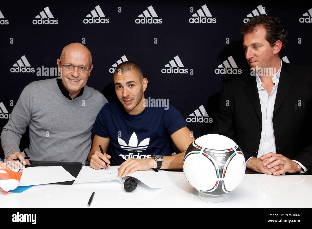 French national soccer team player Karim Benzema (C) poses next to Alain  Pourcelot (L), Brand Director Adidas in France, and Gregory Fernandez, Head  of Football players and scouting at Adidas International, during