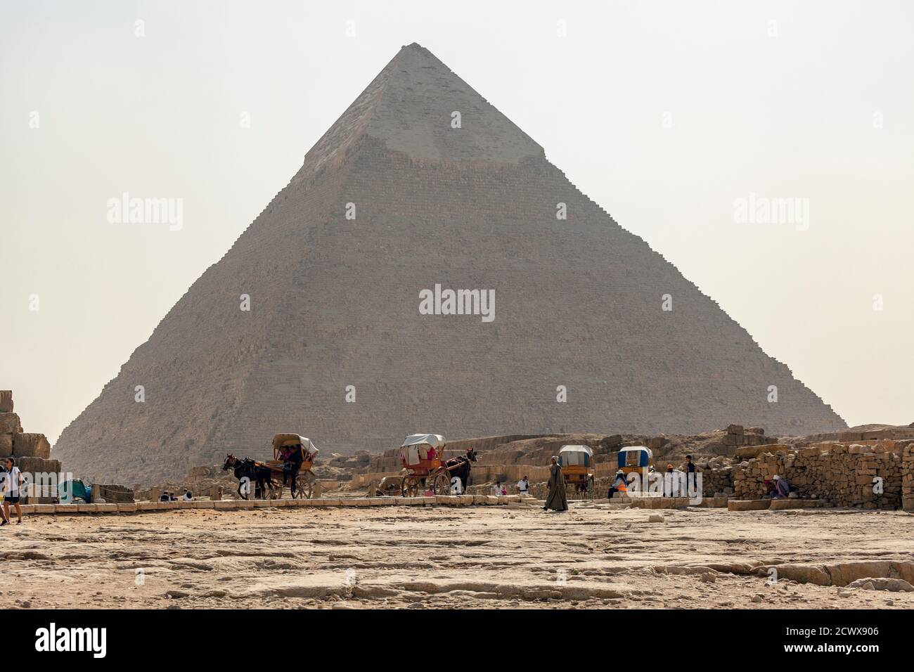 Los jinetes de camellos que están de viaje de negocios por la Pirámide de Khafre En Giza en el Cairo Foto de stock