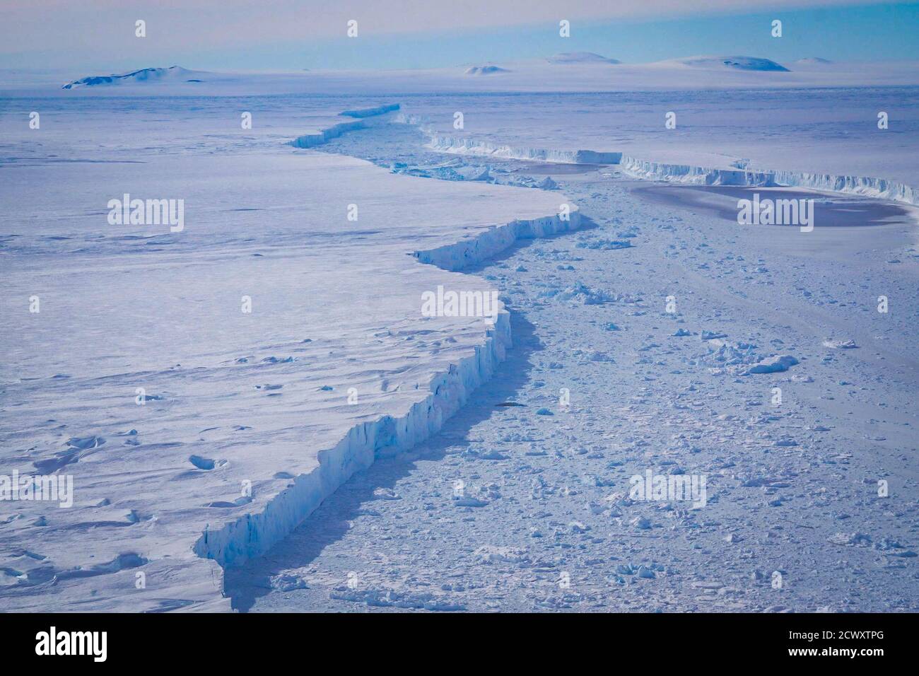 Iceberg antártico masivo manchado en el vuelo IceBridge de la NASA Caption: Una vista de cerca de la grieta que separa el glaciar de la isla de pino y el iceberg B-46, como se vio en un vuelo de la operación IceBridge el 7 de noviembre de 2018. Foto de stock