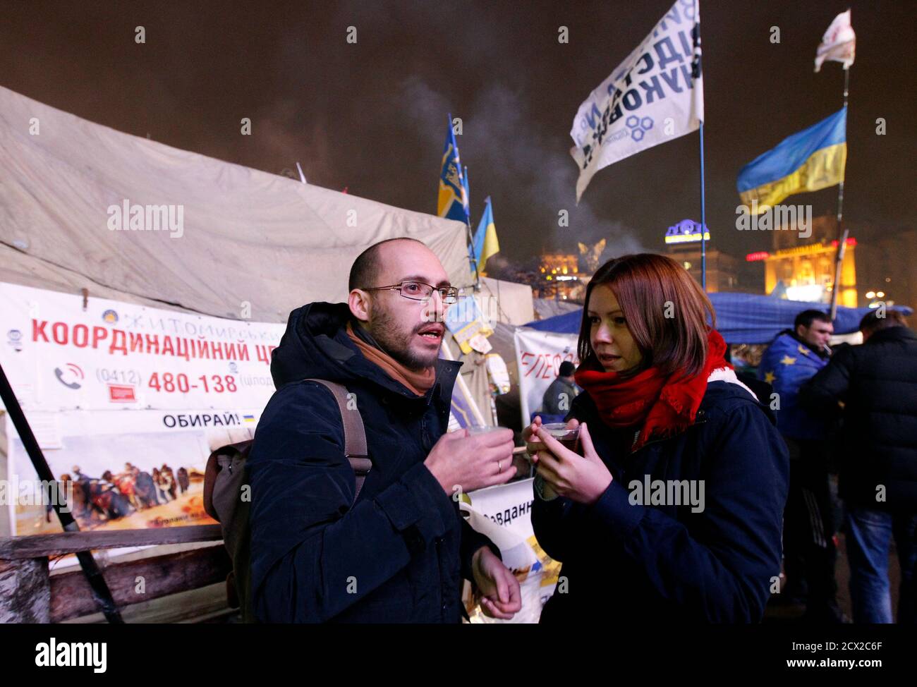Igor Skliarevsky and his wife Elena drink tea in a pro-European protesters camp at Independence Square in Kiev, December 16, 2013. By day, Igor Skliarevsky works as a graphic designer. By night, he is an anti-government protester, sometimes manning the barricades in Ukraine's snowy capital. The 36-year-old delivers maps for fellow protesters, directing them to medical posts or kitchens. He also set up a website coordinating food, warm clothing and other supplies for those camped out on Kiev's Independence Square. Picture taken December 16, 2013. REUTERS/Vasily Fedosenko (UKRAINE - Tags: POLIT Foto de stock