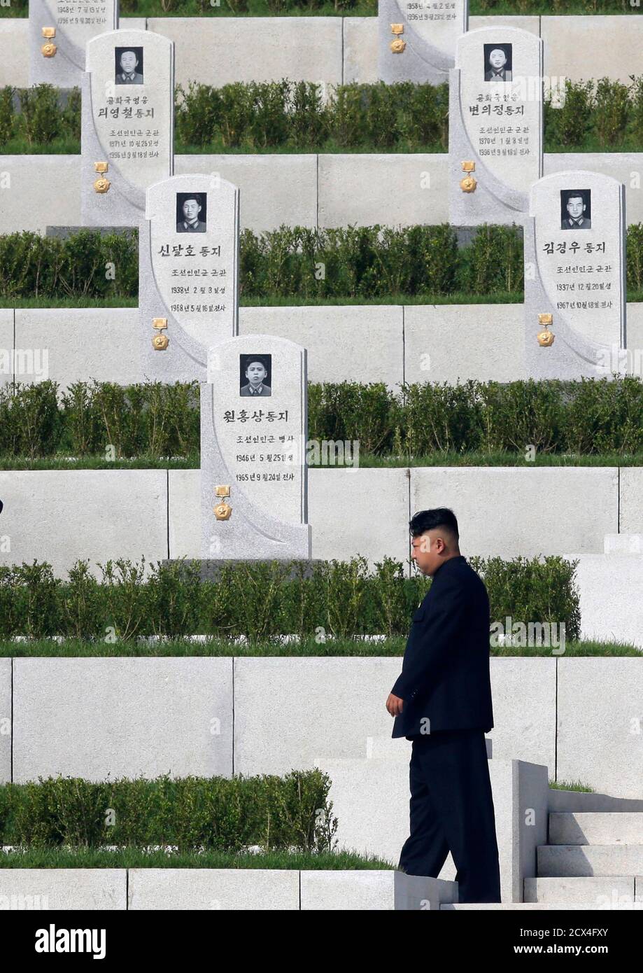 El líder norcoreano Kim Jong-un pasa por lápidas mientras asiste a la ceremonia de apertura del Cementerio de combatientes caídos del Ejército Popular Coreano (KPA) en Pyongyang el 25 de julio de 2013, Como parte de las celebraciones antes del 60 aniversario de la firma de una tregua en la Guerra de Corea de 1950-1953. REUTERS/Jason Lee (COREA DEL NORTE - Tags: ANIVERSARIO POLÍTICA MILITAR) Foto de stock