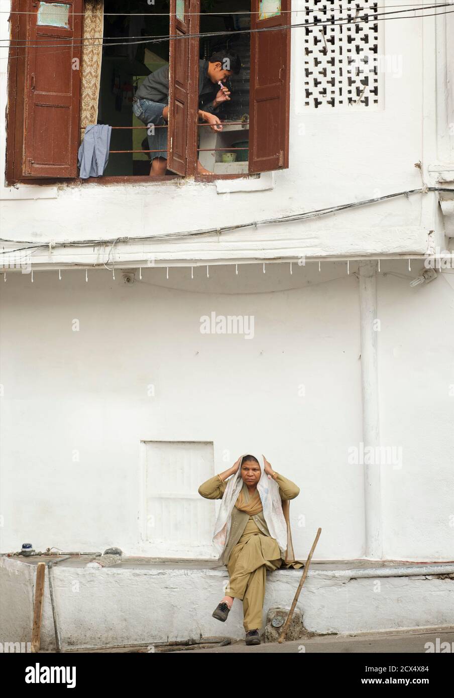 Escena cándida. Mujer India secando el cabello y el hombre cepillando los dientes arriba. Udaipur, Rajasthan, India Foto de stock