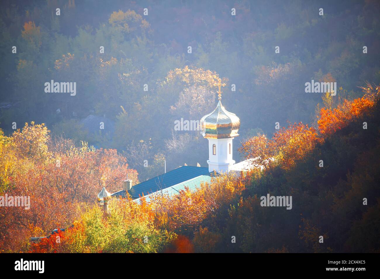 Iglesia Ortodoxa con cúpula dorada situada en la cuesta abajo. Paisaje otoñal con iglesia Foto de stock