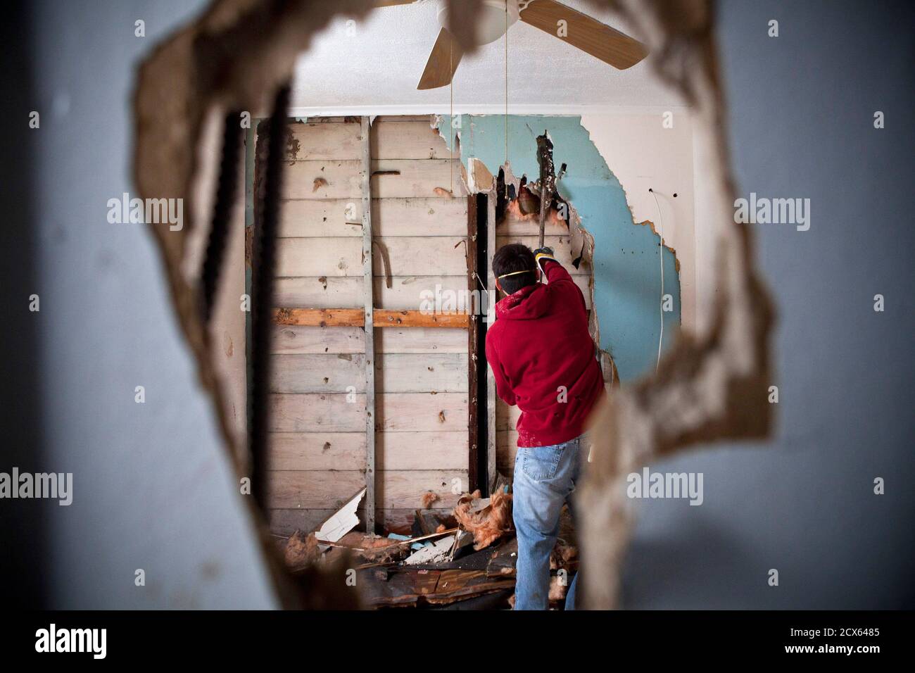 A volunteer helps tear down the dry wall of a house damaged by Hurricane  Sandy in the Midland Beach neighbourhood of Staten Island, New York  November 9, 2012. REUTERS/Andrew Burton (UNITED STATES -
