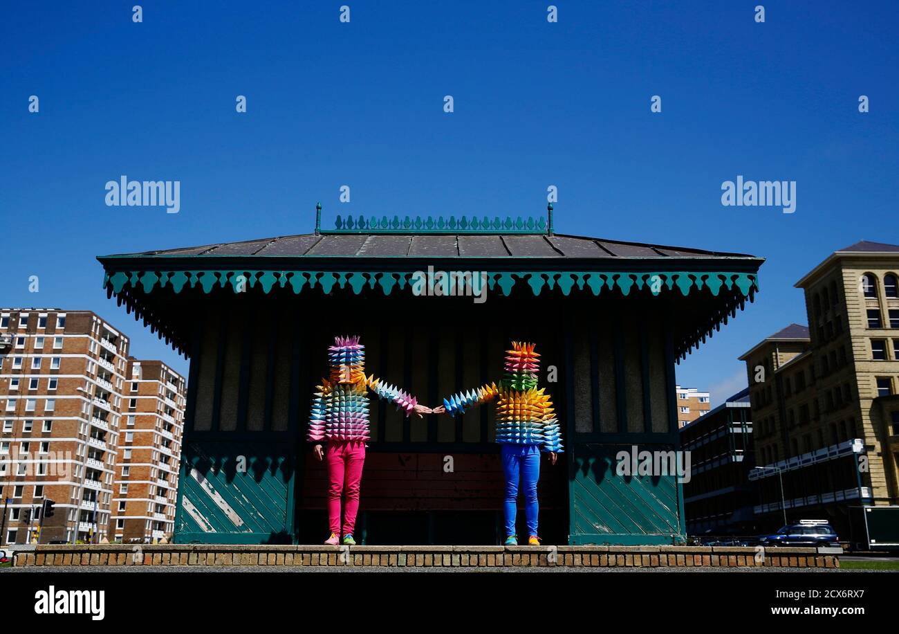 Venezuelan artist Cristobal Ochoa (R) and his performance partner Jean-Paul Fowler promote the Artist Open Houses part of the Brighton Festival with street art performance "Los conos de madre" ("mother's cones"), on the seafront in Brighton May 6, 2014. Artists open their homes during the annual Brighton Festival, now in its 48th year, every weekend during May. Ochoa will be performing at two arts houses in Hove and other venues around the city. REUTERS/Luke MacGregor (BRITAIN - Tags: ENTERTAINMENT SOCIETY) Foto de stock