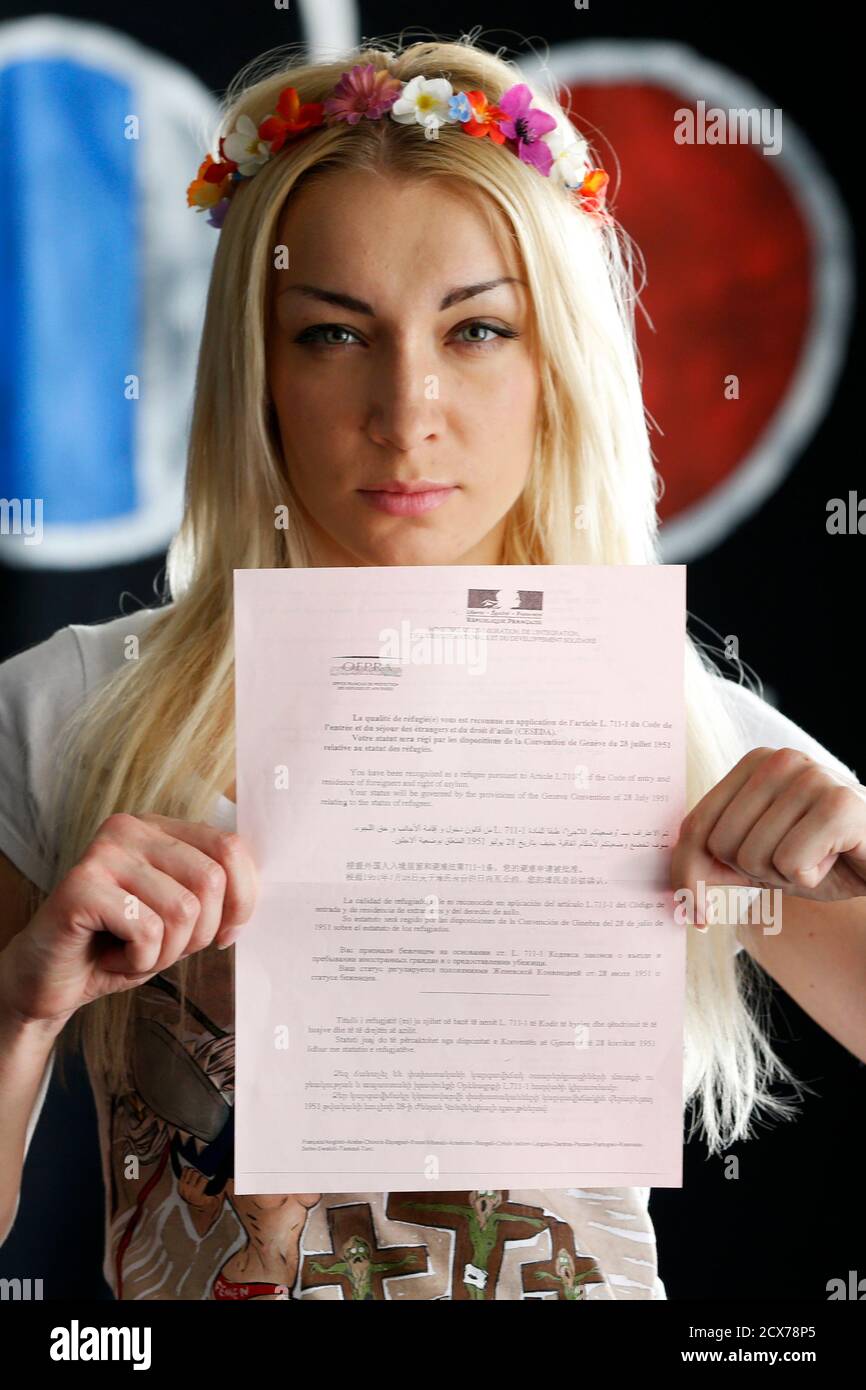 Ukrainian activist Inna Shevchenko, member of the women's rights group  Femen, poses with her OFPRA asylum official document at their 'training  camp' at the Lavoir Moderne Parisen (LMP) in Paris July 8,