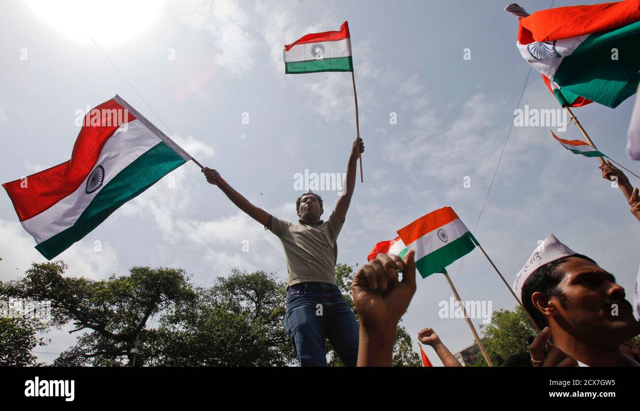 Los partidarios de la veterana activista social India Anna Hazare levantan banderas nacionales indias durante una manifestación de protesta contra la corrupción en Mumbai el 16 de agosto de 2011. La policía arrestó a Hazare el martes, pocas horas antes de que comenzara un ayuno a la muerte, mientras el gobierno atribulado se esforcejaba contra un activista gandhiano de estilo propio que agitaba por una nueva lucha por la 'libertad'. REUTERS/Danés Siddiqui (INDIA - Tags: POLÍTICA DISTURBIOS CIVILES) Foto de stock