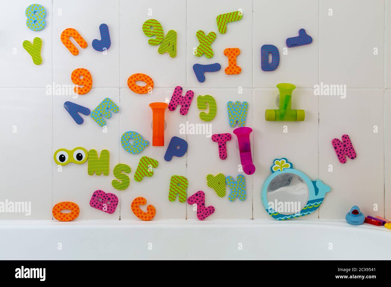 Juguetes de baño con alfabeto infantil en el baño. Foto de stock