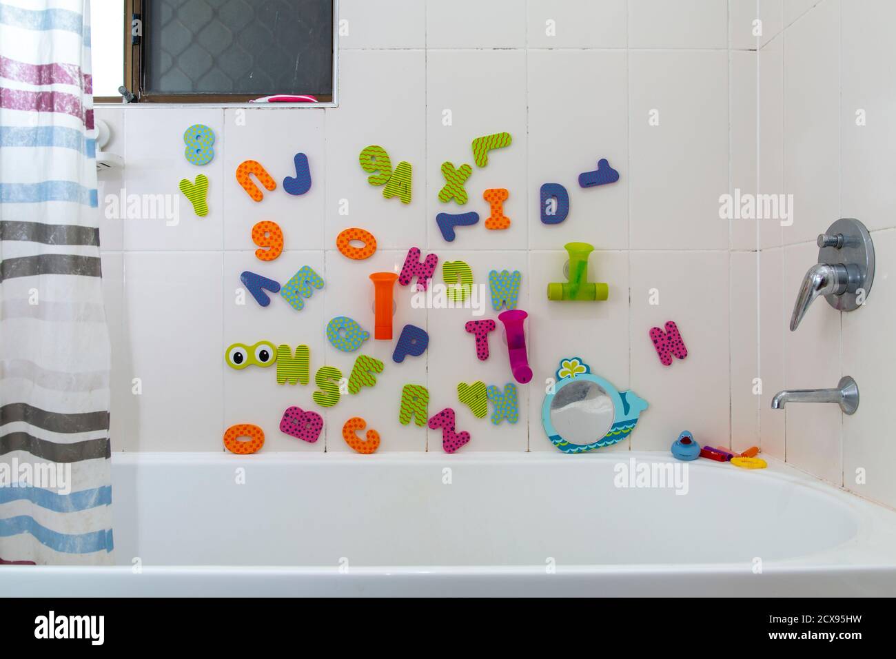 Juguetes de baño con alfabeto infantil en el baño. Foto de stock