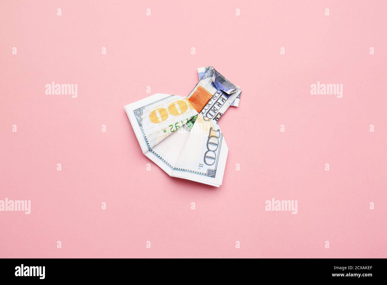 Vestido de origami hecho de billete de dólar sobre fondo de color  Fotografía de stock - Alamy