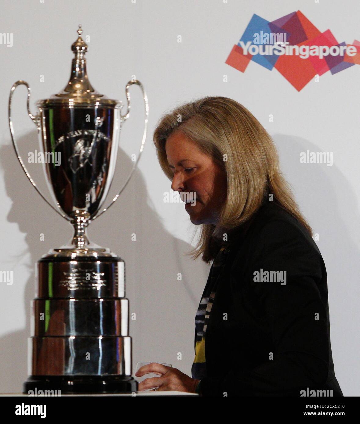 Stacey Allaster, Chairman and Chief Executive Officer of the Women's Tennis Association (WTA), walks past the Billie Jean King trophy during a WTA announcement in Singapore May 8, 2013. From left is Singapore Sports Council's CEO Lim Teck Yin, World Sports Group's Chief Operating Officer Andrew Georgiou and Singapore Tourism Board's CEO Lionel Yeo. Singapore will host the glittering annual finale of the women's tennis season from 2014 until 2018, the WTA said on Wednesday. REUTERS/Edgar Su (SINGAPORE - Tags: SPORT TENNIS) Foto de stock