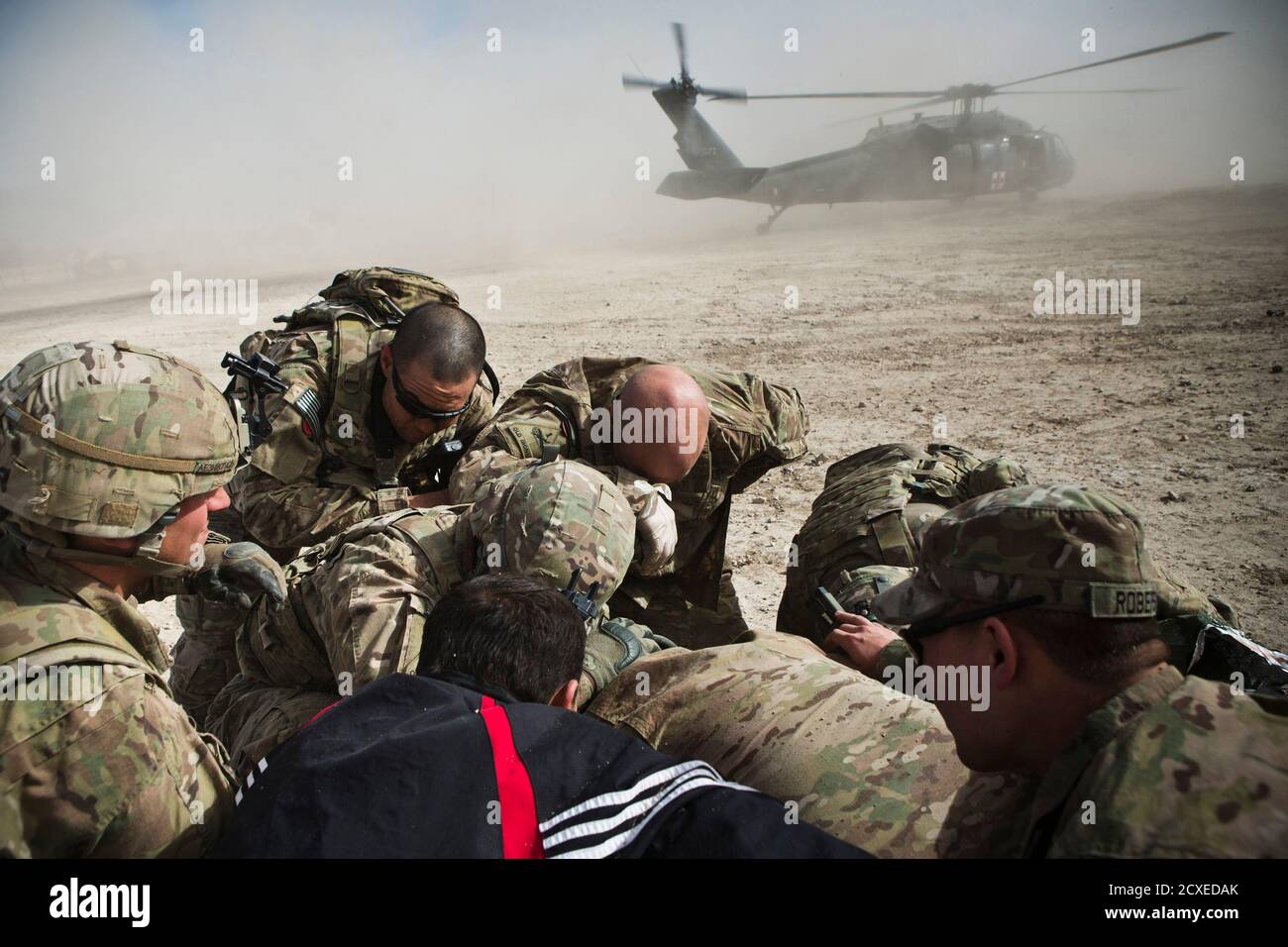 A Translator And Soldiers From 1st Platoon Alpha Company 1st Battalion 36th Infantry Regiment Take Cover From A Helicopter S Rotor Wash While Evacuating A 10 Year Old Girl Injured By An Improvised Explosive Device