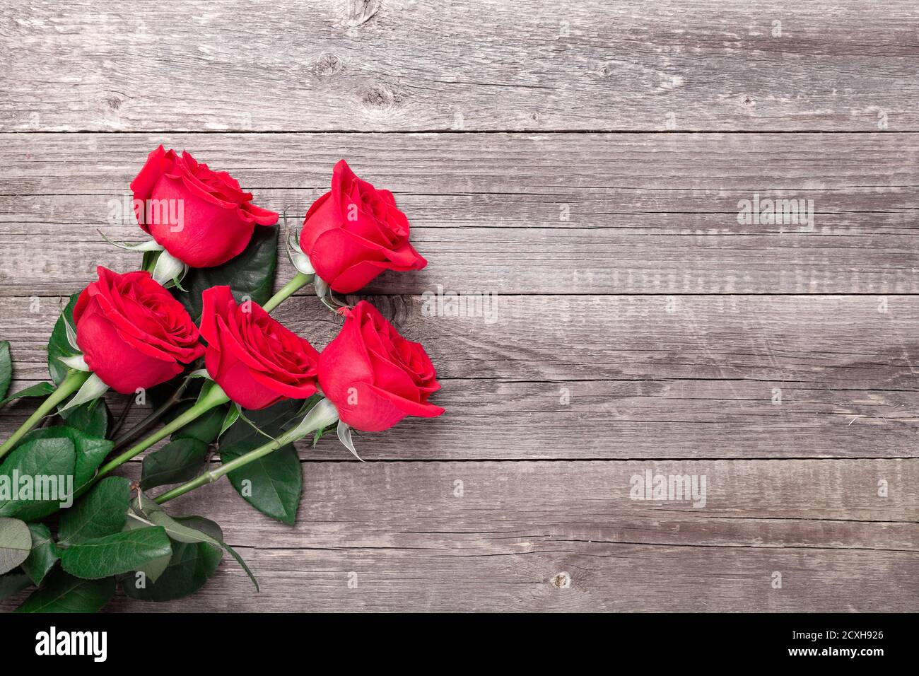 Rosas rojas flores sobre mesa de madera gris. Tarjeta de San Valentín.  Vista superior. Copiar espacio - imagen Fotografía de stock - Alamy