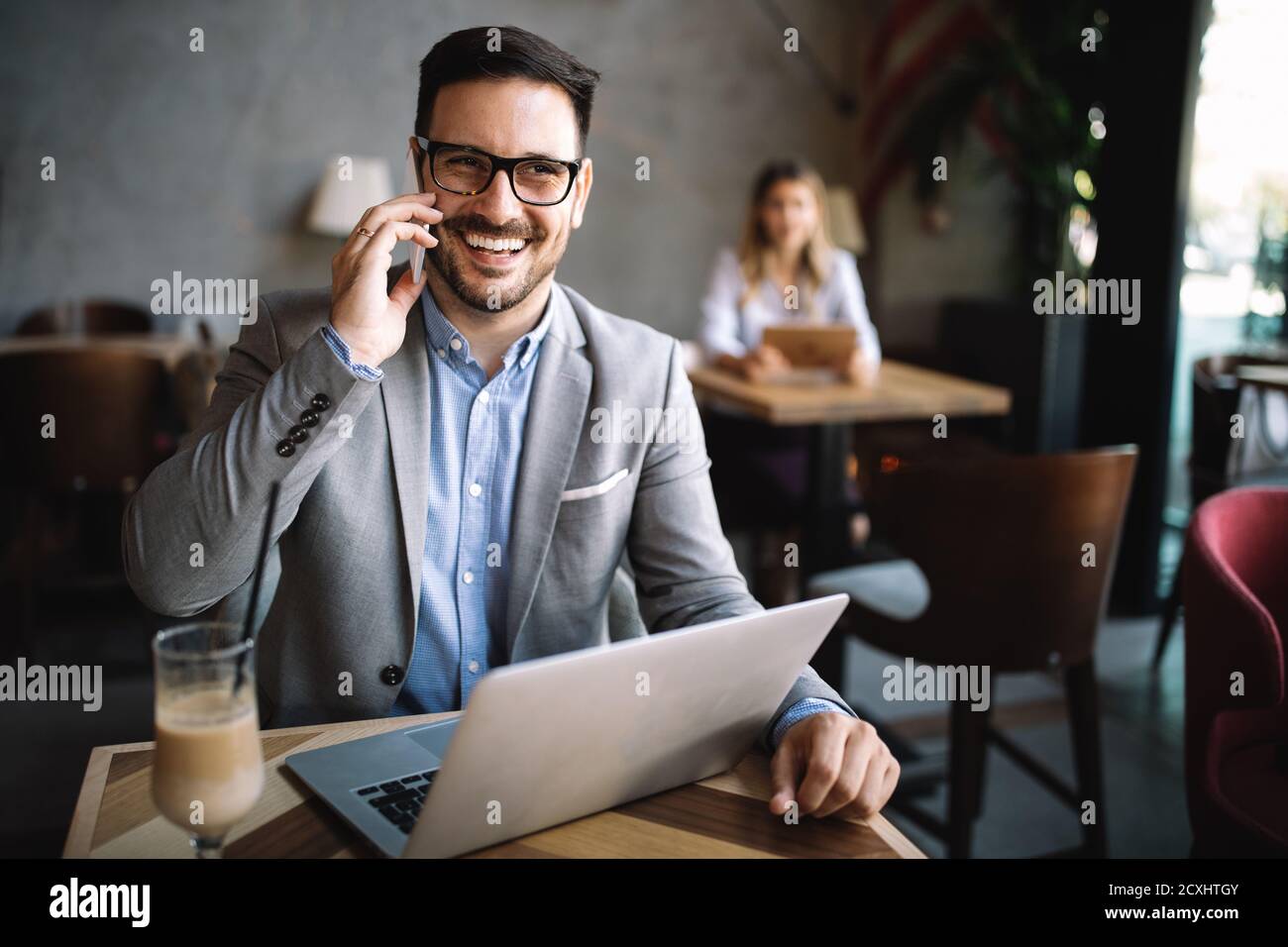 Apuesto hombre de negocios feliz recibir un mensaje en su teléfono celular Foto de stock