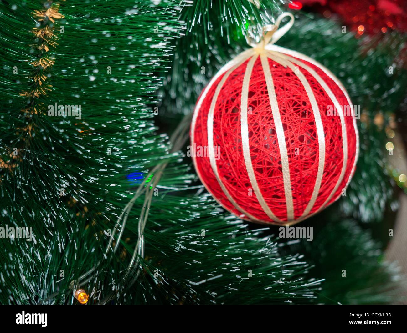 Decoración navideña en forma de bola roja De hilos con una cinta dorada  colgando en una Navidad árbol Fotografía de stock - Alamy