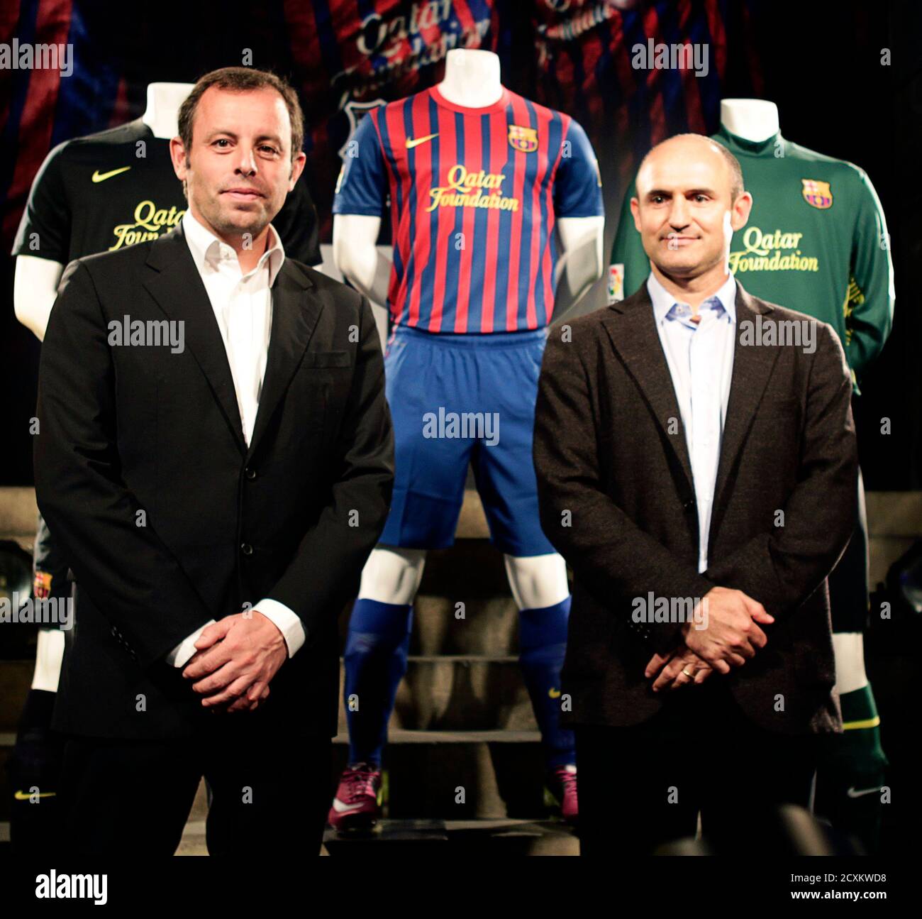 Barcelona's President Sandro Rosell (L) and Nike's Iberia President Marcos pose with the new Barcelona jerseys for the 2011-2012 season with the Qatar Foundation logo during a presentation at Camp Nou