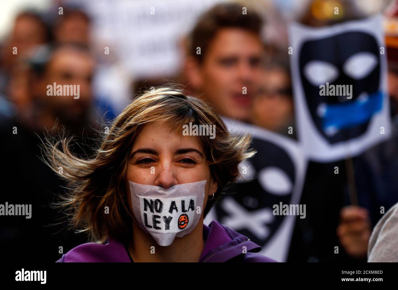 A women with a tape across her mouth reacts during a protest against the Spanish government's new anti-protest security law in Madrid December 20, 2014. A demonstration against Spain's new "Ley Mordaza" anti-protest bill was held on Saturday following its approval by the conservative-led Spanish parliament on December 11 despite heavy opposition from some politicians and activist groups, who say the law violates the right to protest, limits freedom of expression and gives more power to police. The bill will go to the senate next where it is expected to pass as the ruling People's Party also ha Foto de stock