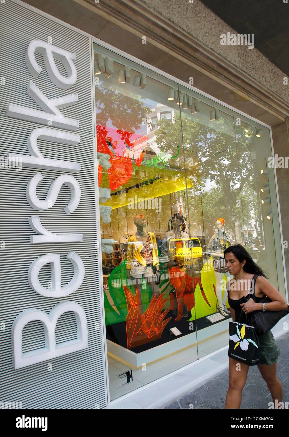 Una mujer pasa por un escaparate de una tienda Bershka, parte de Inditex,  en Barcelona el 13 de junio de 2012. La española Inditex SA, el mayor  minorista de ropa del mundo,