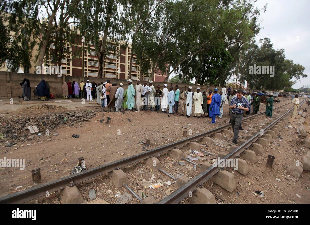 La gente acude a votar en una unidad de votación cerca de una vía férrea en la aldea de Angwa Shanu, en el estado de Kaduna, en el norte de Nigeria, 28 de abril de 2011.los votantes se dirigieron a las mesas de votación el jueves en dos estados del norte de Nigeria, donde los disturbios mataron a cientos la semana pasada. bajo la atenta mirada de policías a caballo y soldados que manan barricadas. REUTERS/Afolabi Sotunde (NIGERIA - Tags: ELECCIONES POLÍTICAS) Foto de stock