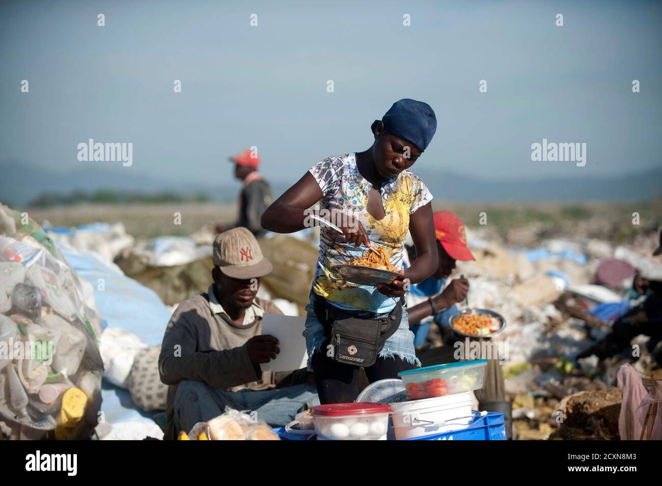 Una mujer vende comida a los recolectores de basura en el basurero de  Duquesa en Santo Domingo 8 de marzo de 2014. El 8 de marzo, activistas de  todo el mundo celebran