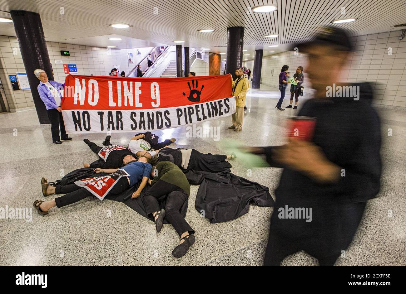 Los manifestantes de la "Red Toronto no Line 9" realizan una "entrada" para demostrar lo que dicen que son los posibles efectos si el Enbridge operó el oleoducto "Line 9", que corre bajo la estación de metro Finch, se rompió, en Toronto, el 29 de junio de 2015. Enbridge ha estado buscando permiso para revertir el flujo del oleoducto que va desde el sur de Ontario hasta Montreal. La Junta Nacional de Energía ha ordenado a Enbridge que realice pruebas hidrostáticas antes de que puedan continuar con el plan, según informes de los medios locales. REUTERS/Mark Blinch Foto de stock