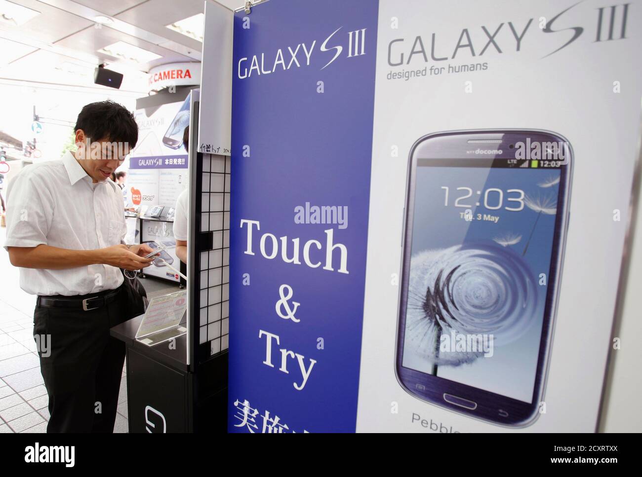 Un cliente prueba un smartphone Galaxy S III de Samsung, lanzado por el mayor operador móvil de Japón NTT Docomo Inc, en una tienda de electrónica en Tokio el 28 de junio de 2012. El Galaxy S III ha recibido las críticas más positivas entre cualquiera de los smartphones Samsung, y el gigante de la tecnología dice que el teléfono está en camino de convertirse en su teléfono inteligente más rápido de venta, con las ventas probablemente a los 10 millones en los primeros dos meses desde su lanzamiento. REUTERS/Yuriko Nakao (JAPÓN - Tags: TECNOLOGÍA DE LAS CIENCIAS EMPRESARIALES) Foto de stock