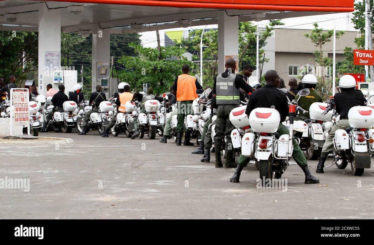 Police queue at a petrol station to pump their motorcycles with fuel before the start of the governorship election in Nigeria's northern state of Kaduna April 28, 2011.Voters trickled out to polling stations on Thursday in two states in northern Nigeria where rioting killed hundreds last week, under the watchful eye of policemen on horseback and soldiers manning barricades.REUTERS/Afolabi Sotunde (NIGERIA - Tags: POLITICS ELECTIONS) Foto de stock