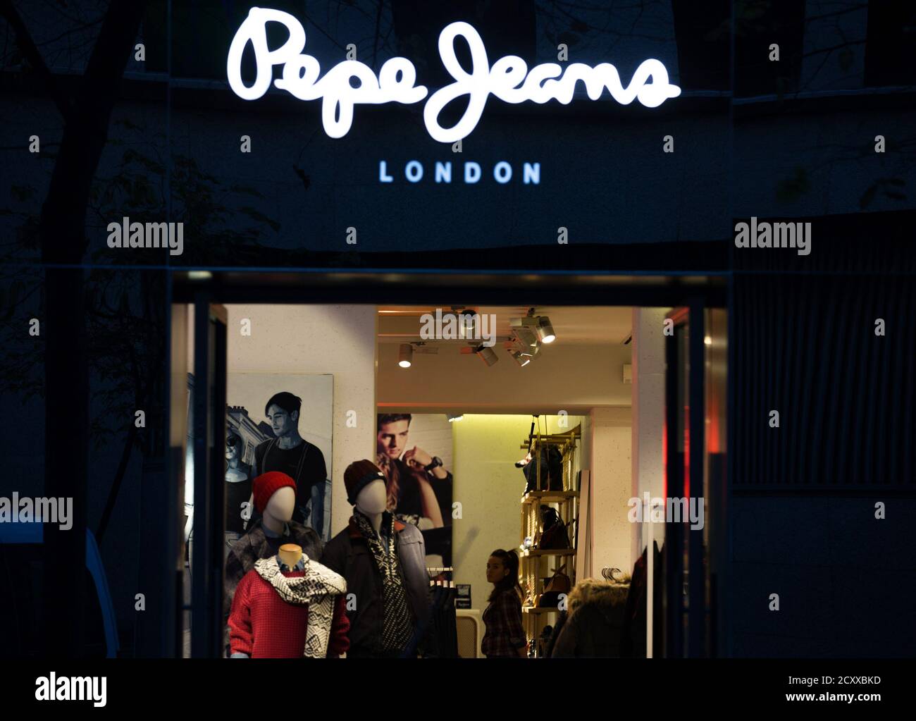 An employee waits for customer inside a shop of the Spanish fashion brand Pepe  Jeans in Madrid December 2, 2014. The Qatari royal family is leading the  race to buy the Spanish